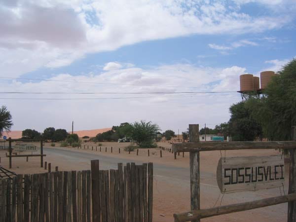 Holzschild mit der Aufschrift Sossusvlei an einem Zaun