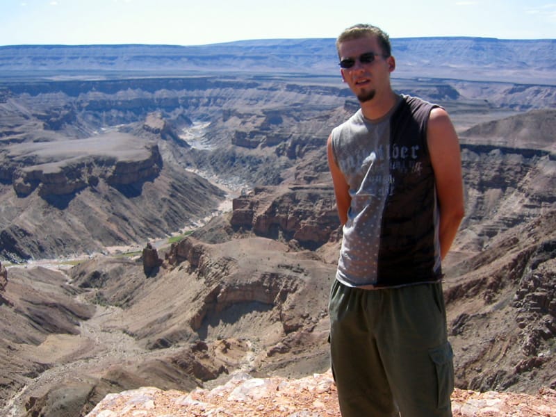 Junger Mann mit Sonnenbrille vor den Windungen des Fish River Canyon