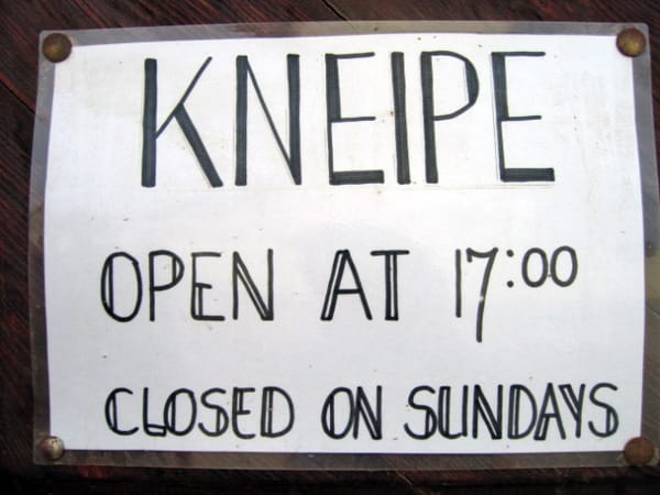 Handgeschriebenes Schild: Kneipe, open at 17:00, closed on Sundays