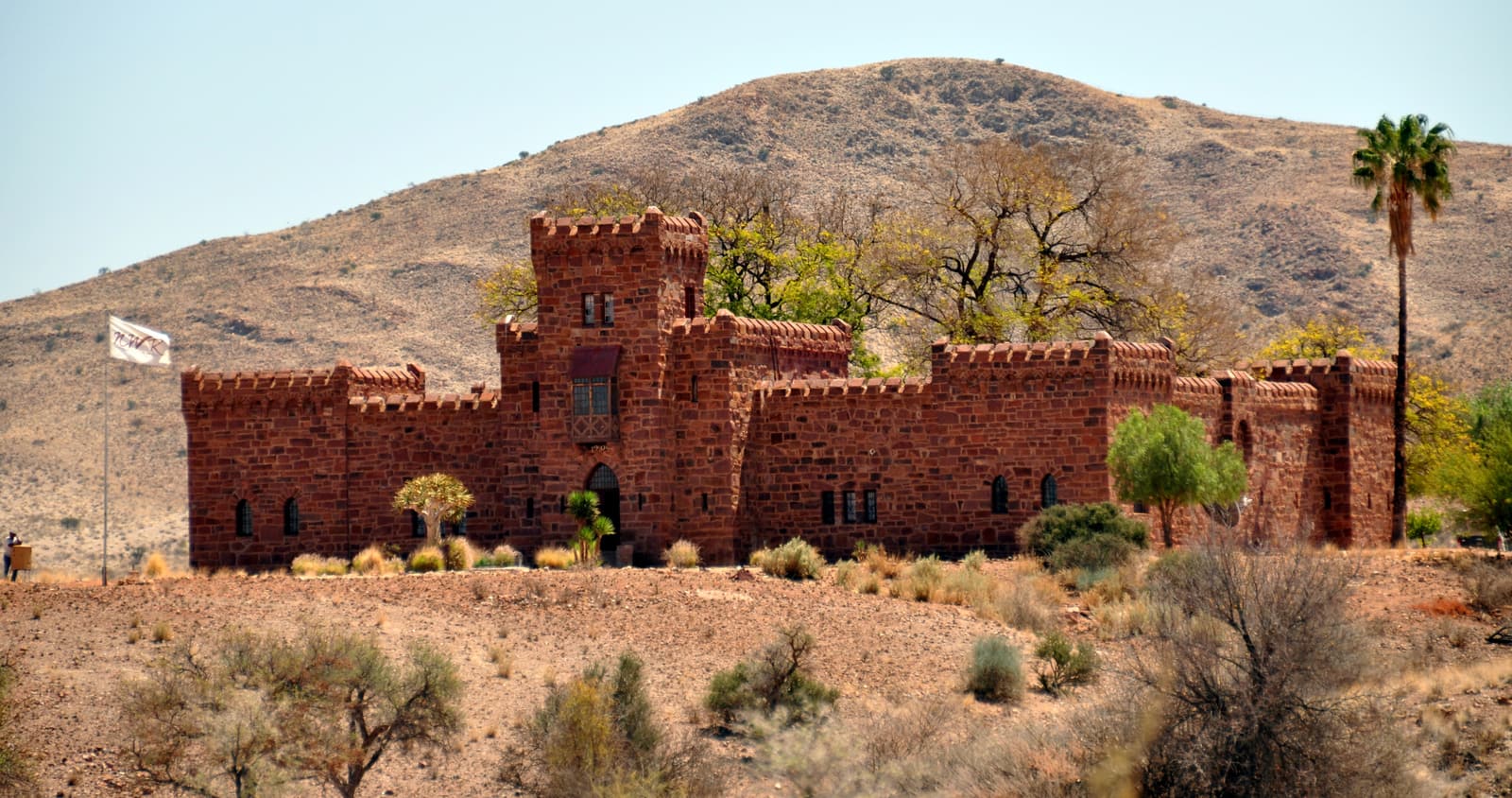 Duwisib Castle in red stone below a bare hill