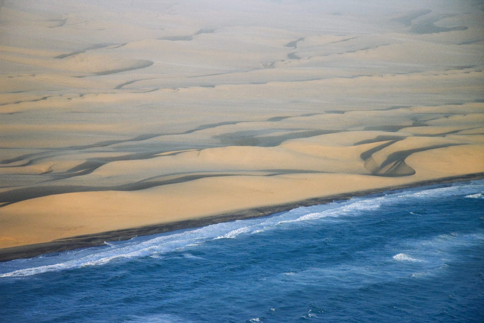 Dünen der Namib, die direkt ins Meer abfallen, aus der Luft